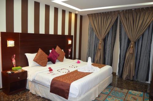 a hotel room with a large bed with a clock on it at قصر البرونز in Al Khobar