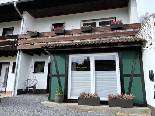 a house with potted plants and a balcony at harmony holiday in Jünkerath