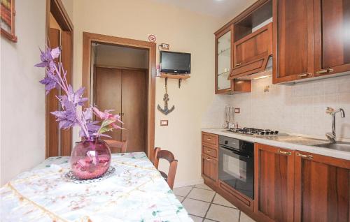 a kitchen with a table with a vase of flowers on it at Amazing Home In S M Di Castellabate in Castellabate