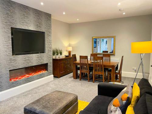 a living room with a fireplace and a dining room at 2Bed, Private Garden & Fireplace, Near Water of Leith in Edinburgh