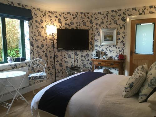 a bedroom with a bed with a tv on the wall at Tullybeggs B&B in Clifden
