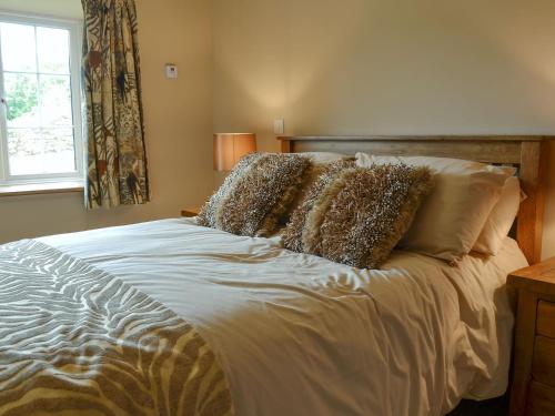 um quarto com uma cama branca com almofadas e uma janela em Tryfan - Uk6628 em Pen-y-groes