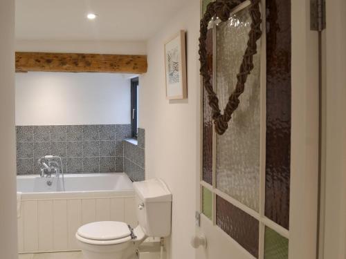 a bathroom with a toilet and a bath tub at 9 Chapel Street in Mousehole