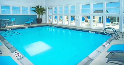 une grande piscine avec de l'eau bleue et des chaises dans l'établissement Holiday Inn Express Nags Head Oceanfront, an IHG Hotel, à Nags Head
