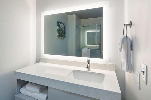 a bathroom with a sink and a mirror at Four Points by Sheraton Plano in Plano