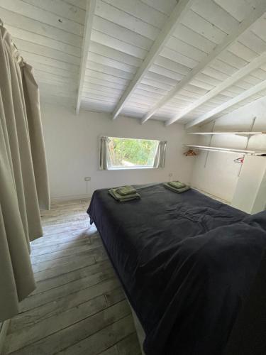 Cama grande en habitación con ventana en Casita del Faldeo en San Carlos de Bariloche