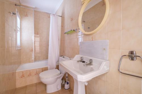 bagno con lavandino, servizi igienici e specchio di Apartamento las Palmeras 3 a Benicarló