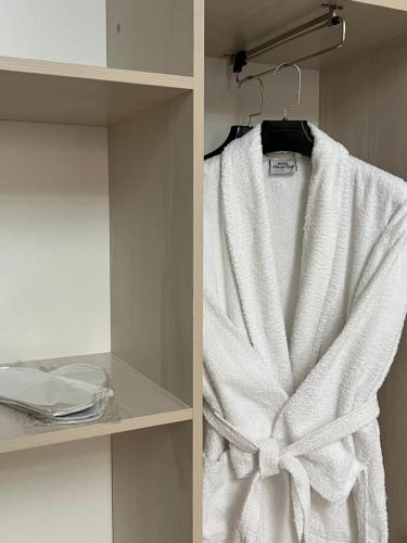 a white towel is hanging on a shelf at Bastau Hotel in Almaty
