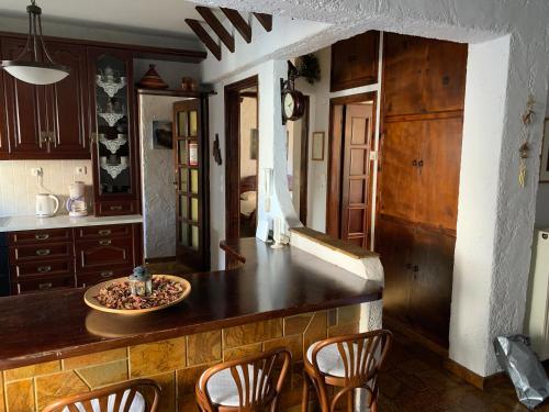 une cuisine avec des placards en bois et un comptoir avec des chaises dans l'établissement The Rustic Hug, à Athènes