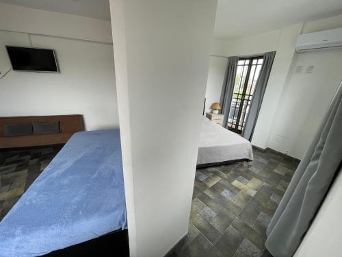a bedroom with a bed and a television in a room at Alquiler Temporario Azcuénaga in Morón