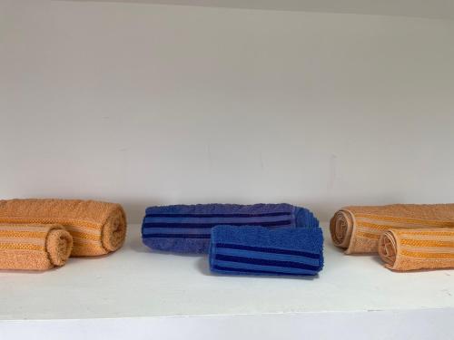 um grupo de diferentes toalhas coloridas sentadas numa prateleira em Alquiler Temporario Azcuénaga em Morón