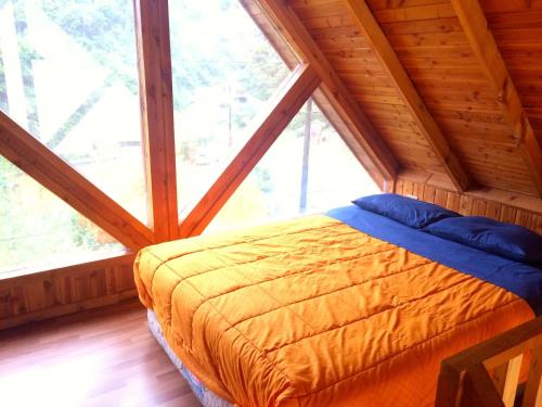 a bed in a room with a large window at Refugio de Caty in Bahía Mansa