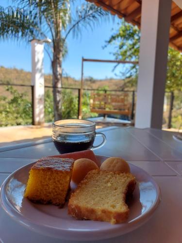 um prato branco com pão e uma tigela de molho em Suítes Canaã em Capitólio