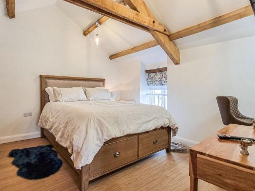a bedroom with a bed and a desk and a chair at The Smythy in Stawley