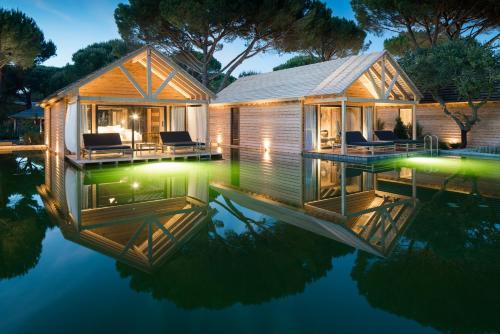 a house with a reflection in the water at night at Sublime Comporta Country Retreat & SPA in Comporta