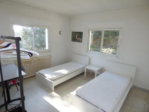 een slaapkamer met een bed, een bureau en 2 ramen bij Haut de villa, pleine vue mer in Saint-Mandrier-sur-Mer