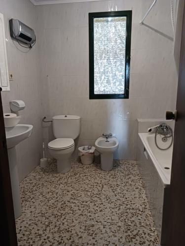 uma casa de banho com 2 WC, um lavatório e uma janela em Casa Don Julio em Jimera de Líbar