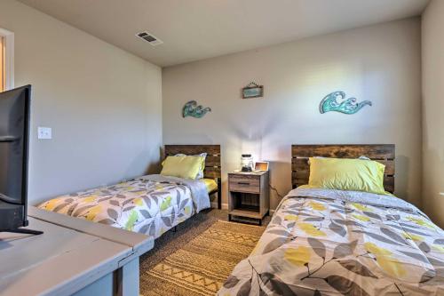 two beds in a room with a tv and a desk at Camden Ocean Springs House Near Beaches! in Ocean Springs