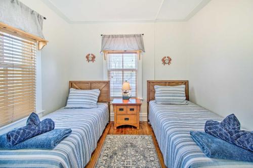 two twin beds in a room with a window at North Beach Cottage - Walk to Chesapeake Bay in North Beach