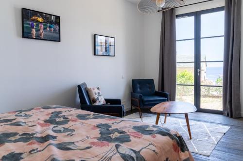 une chambre avec un lit et deux chaises et une fenêtre dans l'établissement Casa lunga, 8 pax, clim, vue mer, piscine, à Brando