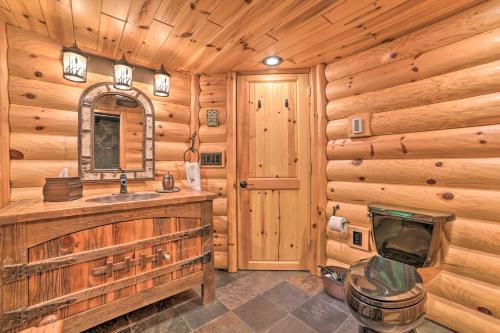 uma casa de banho com um lavatório e uma televisão num chalé de madeira em Dreamy Cabin Steps to Thumb Lake Swim and Fish em Boyne Falls
