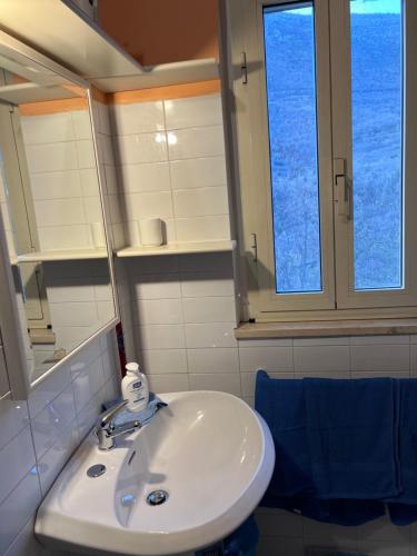 un lavandino bianco in un bagno con due finestre di PAGLIUCO Casa in campagna a Sulmona