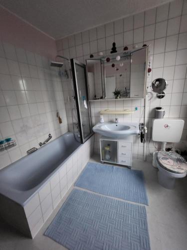 a bathroom with a tub and a sink and a toilet at Gästezimmer Sakowski in Lörrach