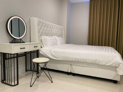 Dormitorio con cama con espejo y taburete en Minimalist Cozy Apartment by MESA, en Nagoya