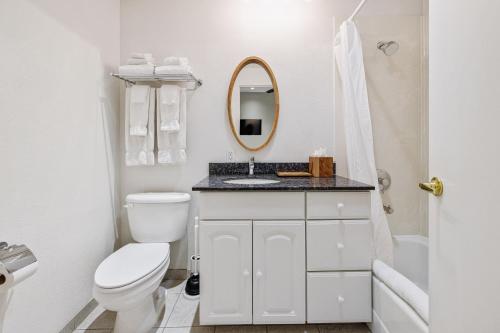 a white bathroom with a toilet and a sink at Pier View Suites - Townhouse B in Cayucos