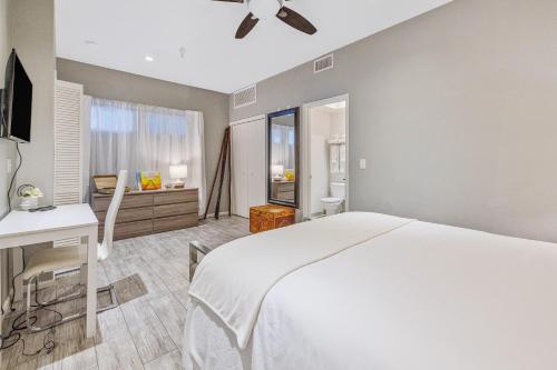 a bedroom with a white bed and a desk at Pier View Suites - Townhouse B in Cayucos