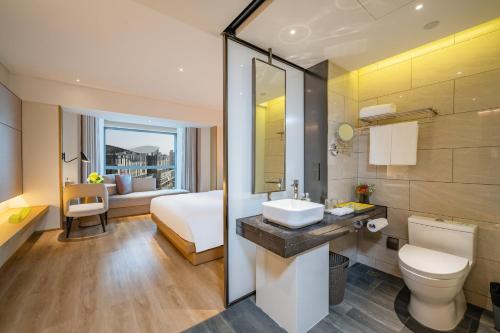 a bathroom with a sink and a bed in a room at Holiday Inn Shanghai Huaxia by IHG - overlooking city scenery at Sky View Restaurant in Shanghai