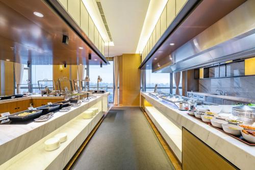 a large kitchen with a long line of counters at Holiday Inn Shanghai Huaxia by IHG - overlooking city scenery at Sky View Restaurant in Shanghai