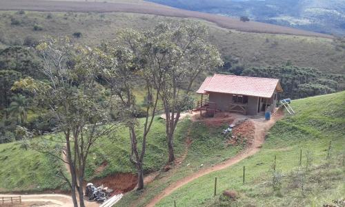 una vista aérea de una pequeña casa en una colina en Pousada Recanto do Ypê en Aiuruoca