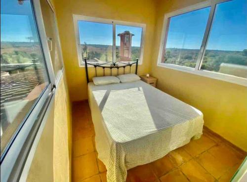 a bedroom with a bed in a room with windows at Villas2meet Can somni in Ses Salines