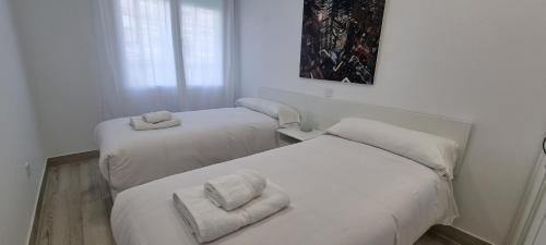 a room with two beds with towels on them at APTO TANEZ NEW YORK STYLE, a in Madrid