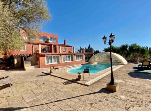 a house with a swimming pool and a street light at Villas2meet Can somni in Ses Salines