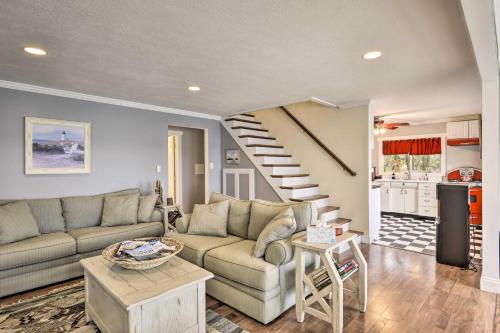 a living room with a couch and a staircase at Waterfront Cottage on Sawmill Bay with Deck! in Clayton