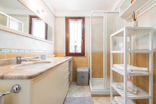 een badkamer met een wastafel en een douche bij Attico il Mandorleto in Villasimius