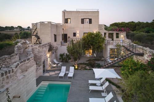 a house with a swimming pool next to a building at Villa Rocce Bianche in Favignana