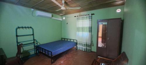 una camera con un letto in una stanza con pareti verdi di Aache Veedu Farm House a Jaffna