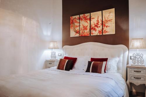 サンレモにあるSweet Home Sanremoのベッドルーム1室(白い大型ベッド1台、ナイトスタンド2台付)