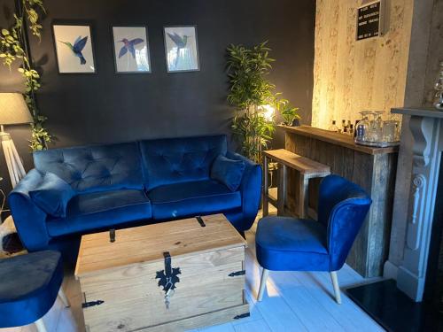 a living room with a blue couch and two chairs at Willow Guest House in Norwich