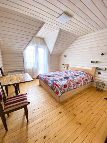 um quarto com uma cama e piso em madeira em Royal Yablunytsya em Yablunytsya