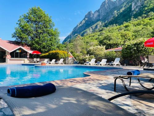 蒙特雷的住宿－Hotel Chipinque，一个带椅子的游泳池,背景是山脉