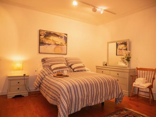 a bedroom with a bed and two chairs and a mirror at Adirondack Mountain View Retreat in Elizabethtown