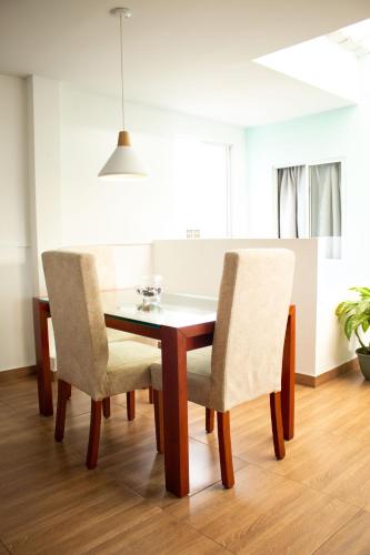 a dining room table with two chairs and a table at Hotel Brisas De Calima in Cali