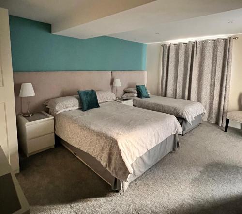 1 dormitorio con 2 camas y pared azul en Reynolds Farm Guesthouse, en Canterbury