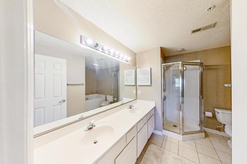 a white bathroom with a sink and a shower at Tidewater Retreat in North Myrtle Beach