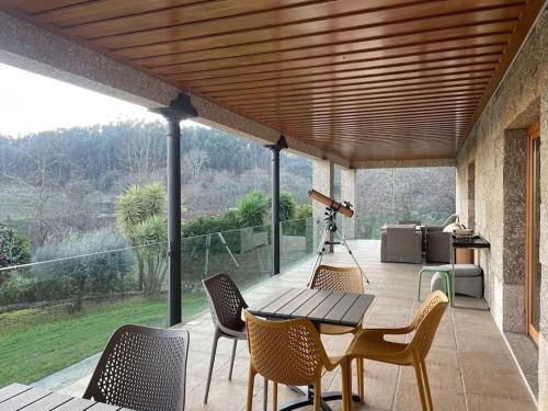 a patio with a table and chairs on a deck at Quinta Picouto de Cima in Guimarães