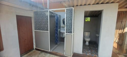a bathroom with a shower and a toilet at Aache Veedu Farm House in Jaffna